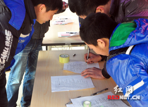 一名学生正在将自己心中的“湖南精神”填写在表单上。